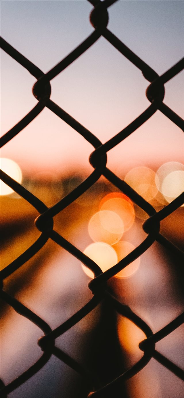 Bokeh behind a fence iPhone X wallpaper 