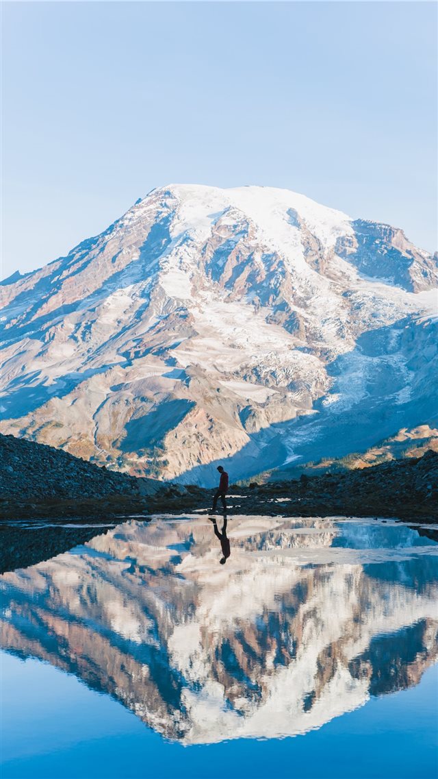 man walking near glacier mountain during day iPhone 8 wallpaper 