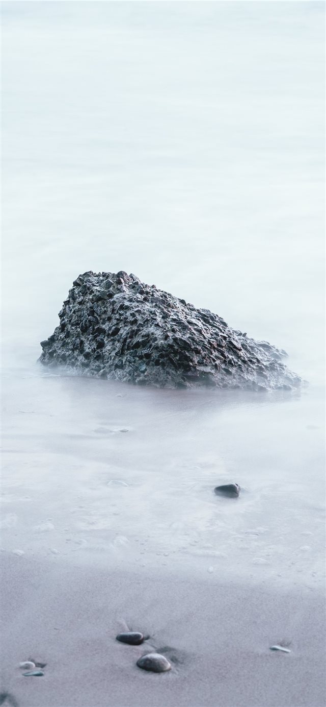 rock on sand shore during day iPhone X wallpaper 