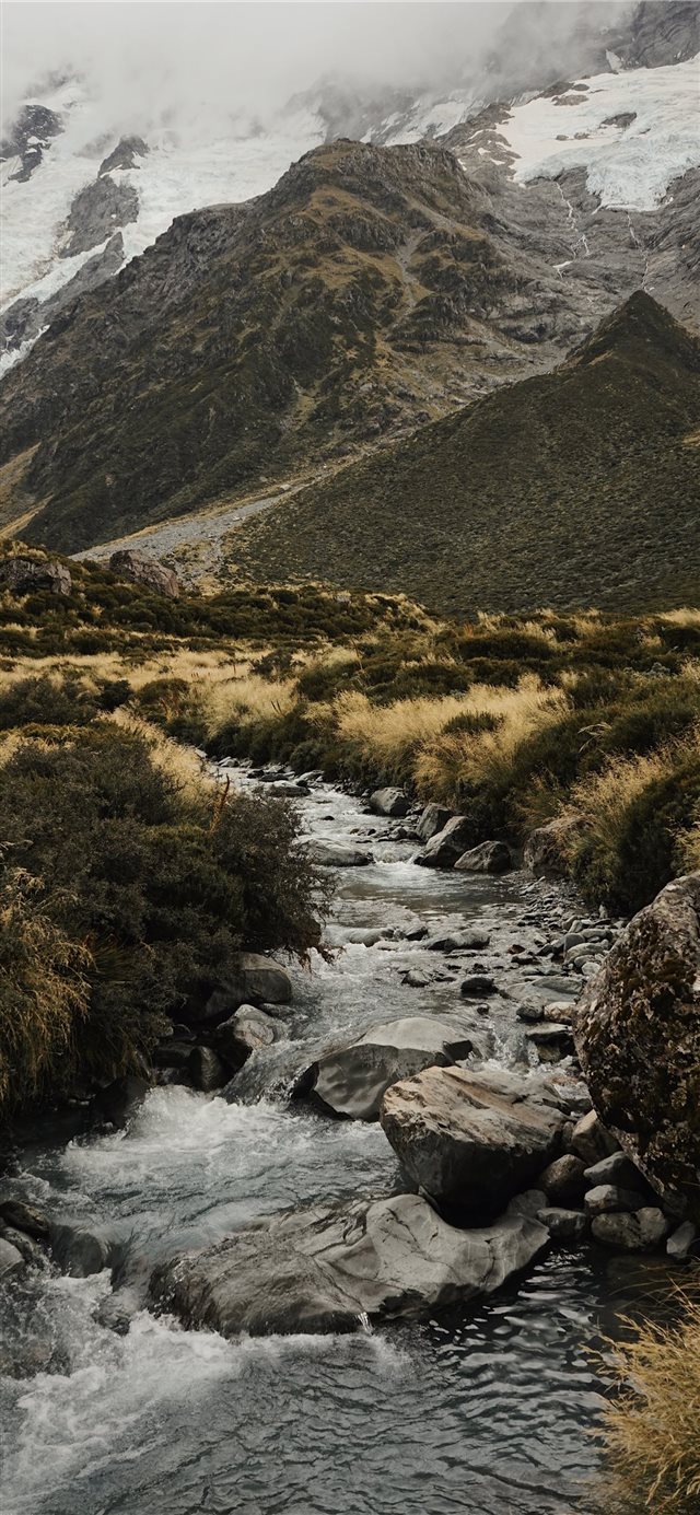 water stream near mountains iPhone X wallpaper 