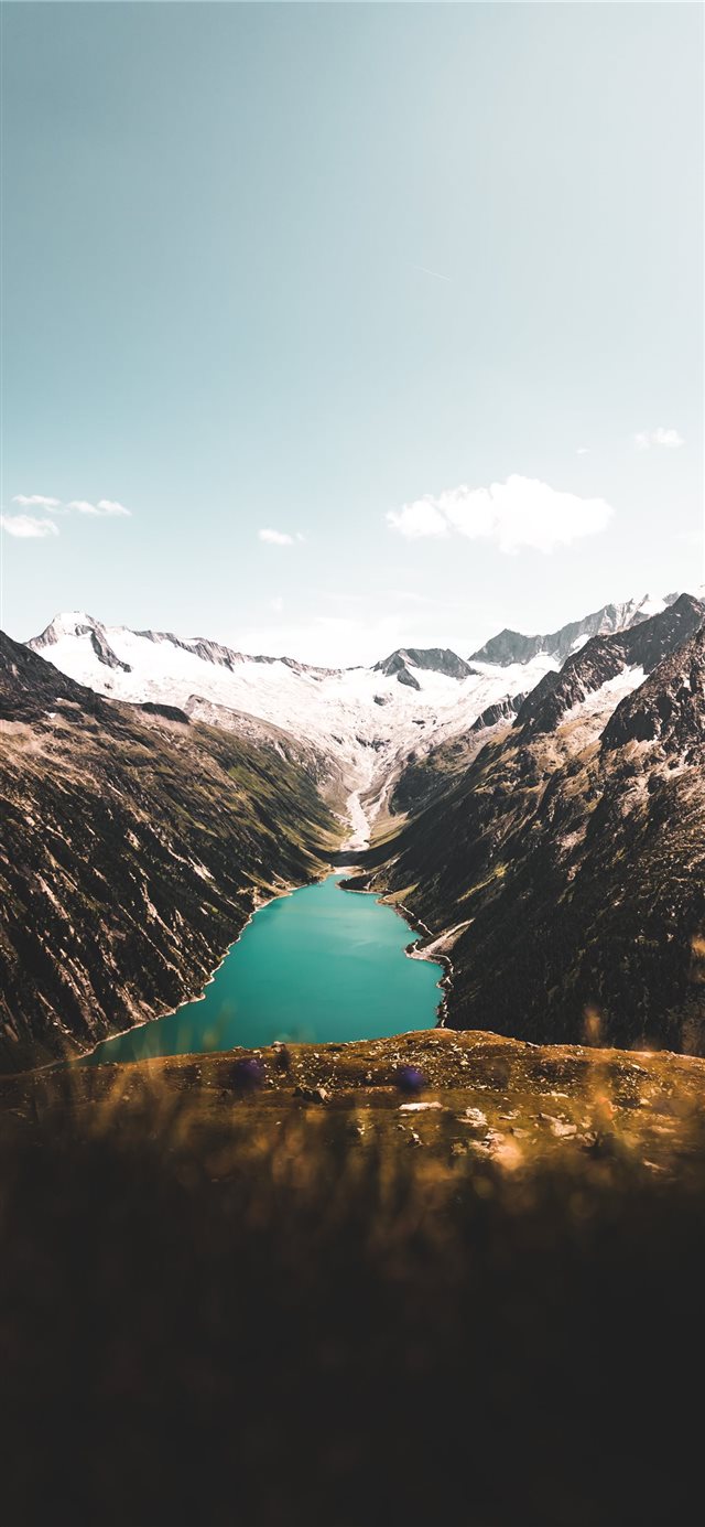 aerial photography of body of water between mounta... iPhone X wallpaper 