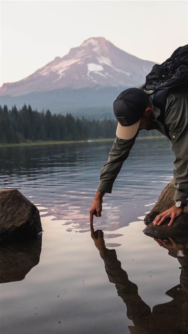 man putting finger on water viewing mountain iPhone 8 wallpaper 