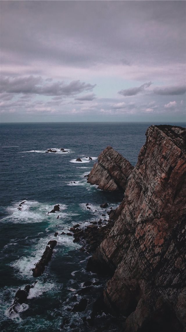 rock formation near the sea during daytime iPhone 8 wallpaper 