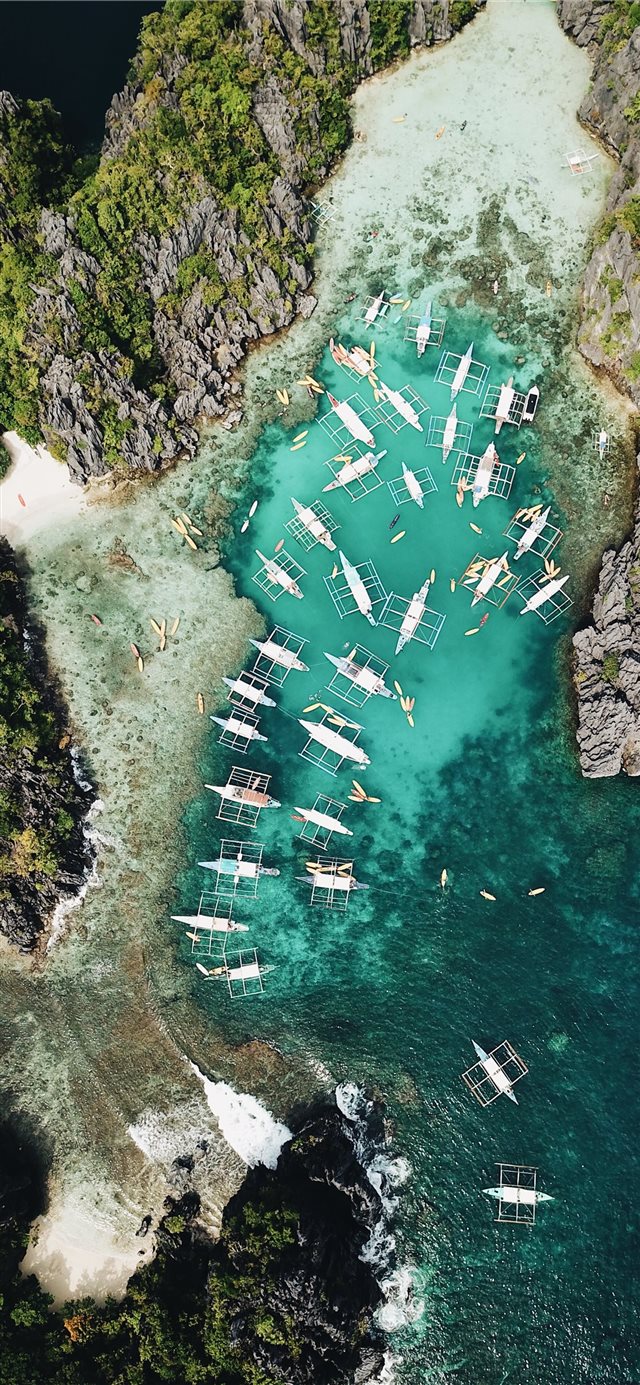 aerial photography of boats beside mountain during... iPhone X wallpaper 
