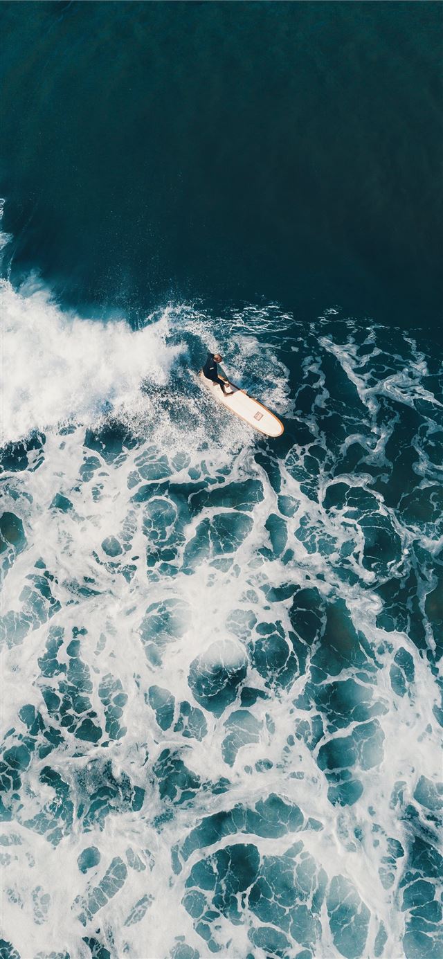 person surfing on sea waves during daytime iPhone X wallpaper 