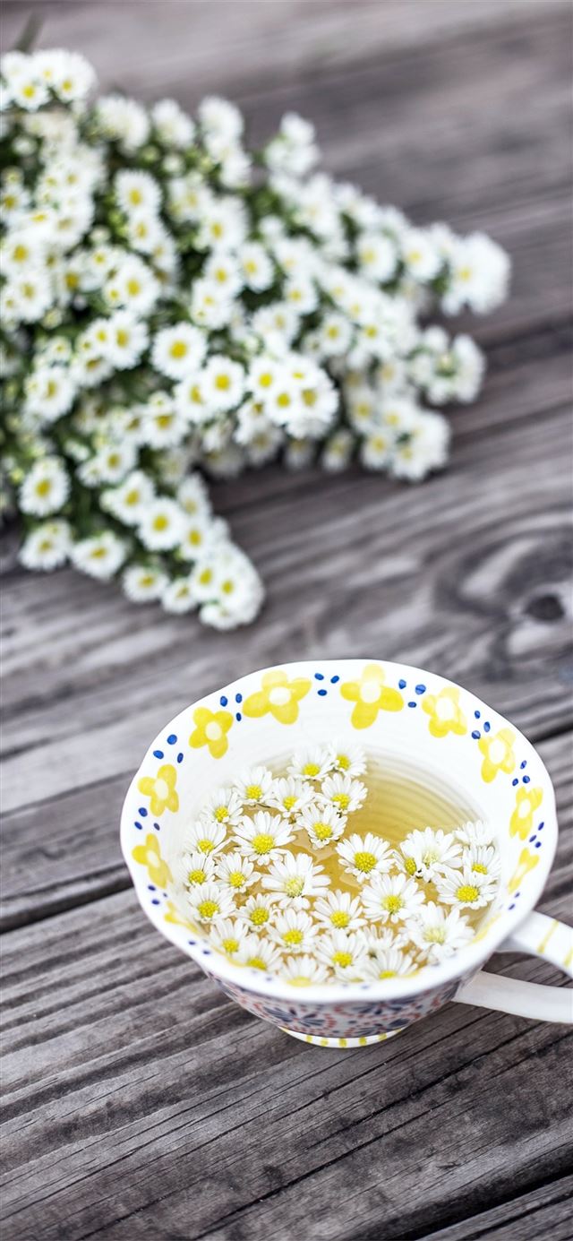 white and yellow cup with flowers on table iPhone X wallpaper 