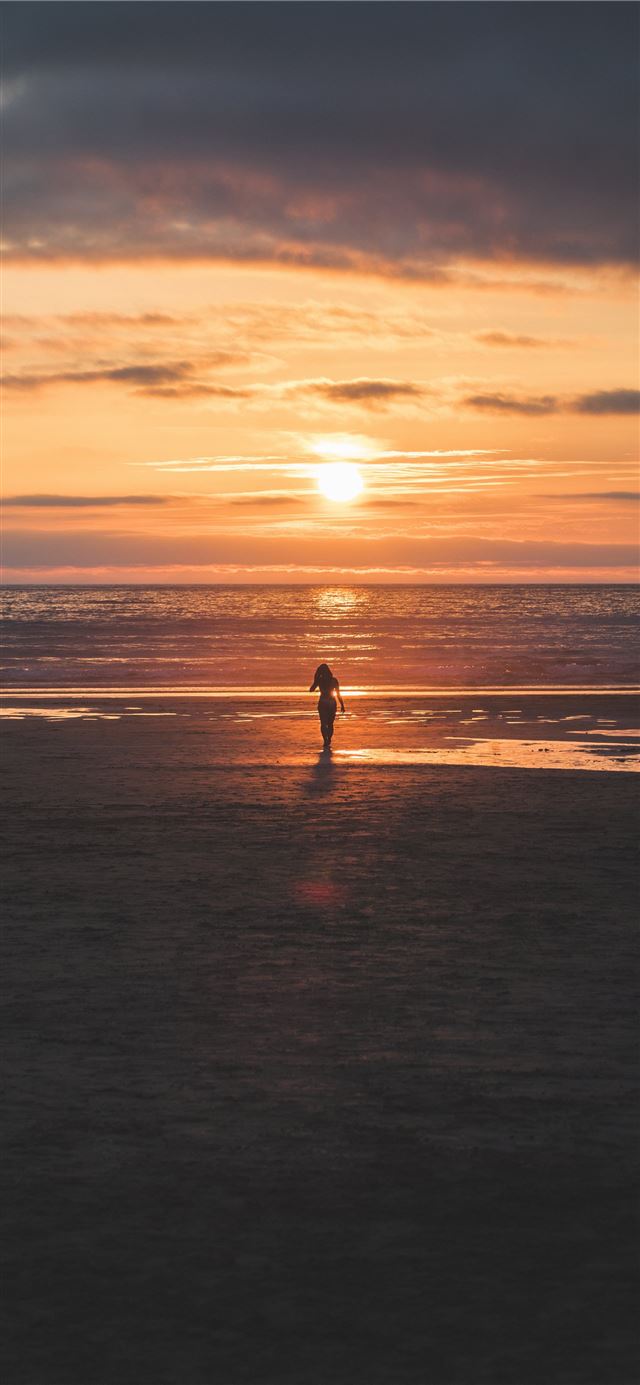 silhouette of woman standing on seashore iPhone 8 wallpaper 