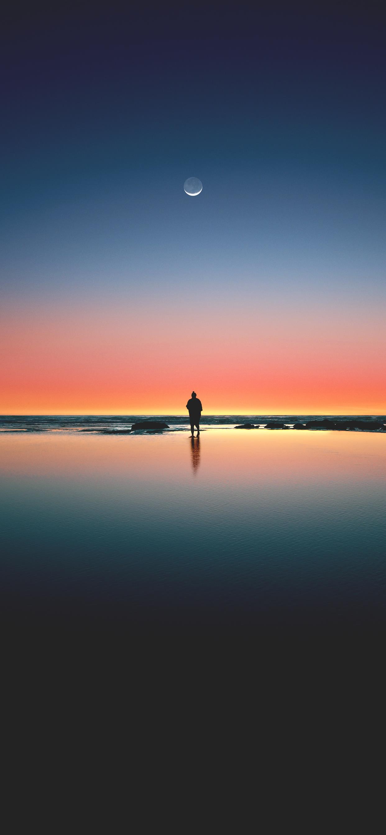 silhouette of man standing on seashore iPhone 11 Wallpapers Free Download