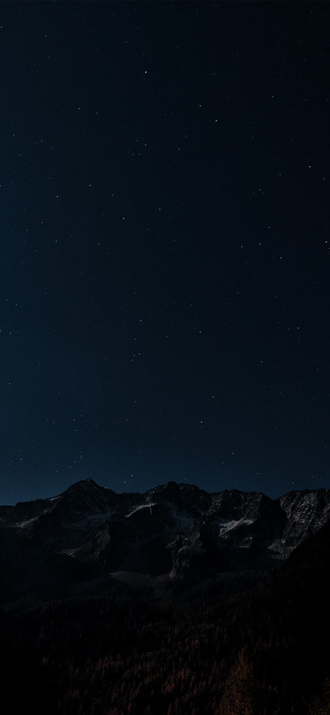gray and brown mountains under starry night photo iPhone wallpaper 