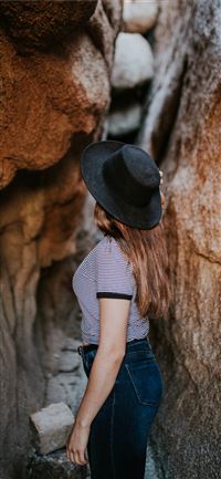 woman standing between narrow cave pathway wallpaper