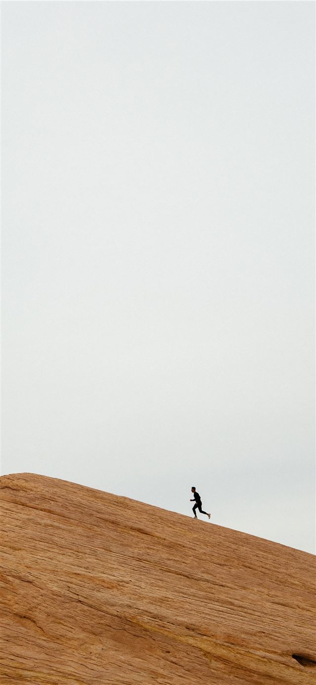 1125x2436 person running on top on hill during daytime -  iPhone 11 Wallpaper