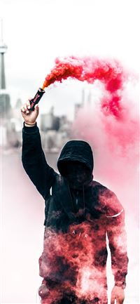 person wearing black and red hoodie holding smoke ... iPhone 11 wallpaper
