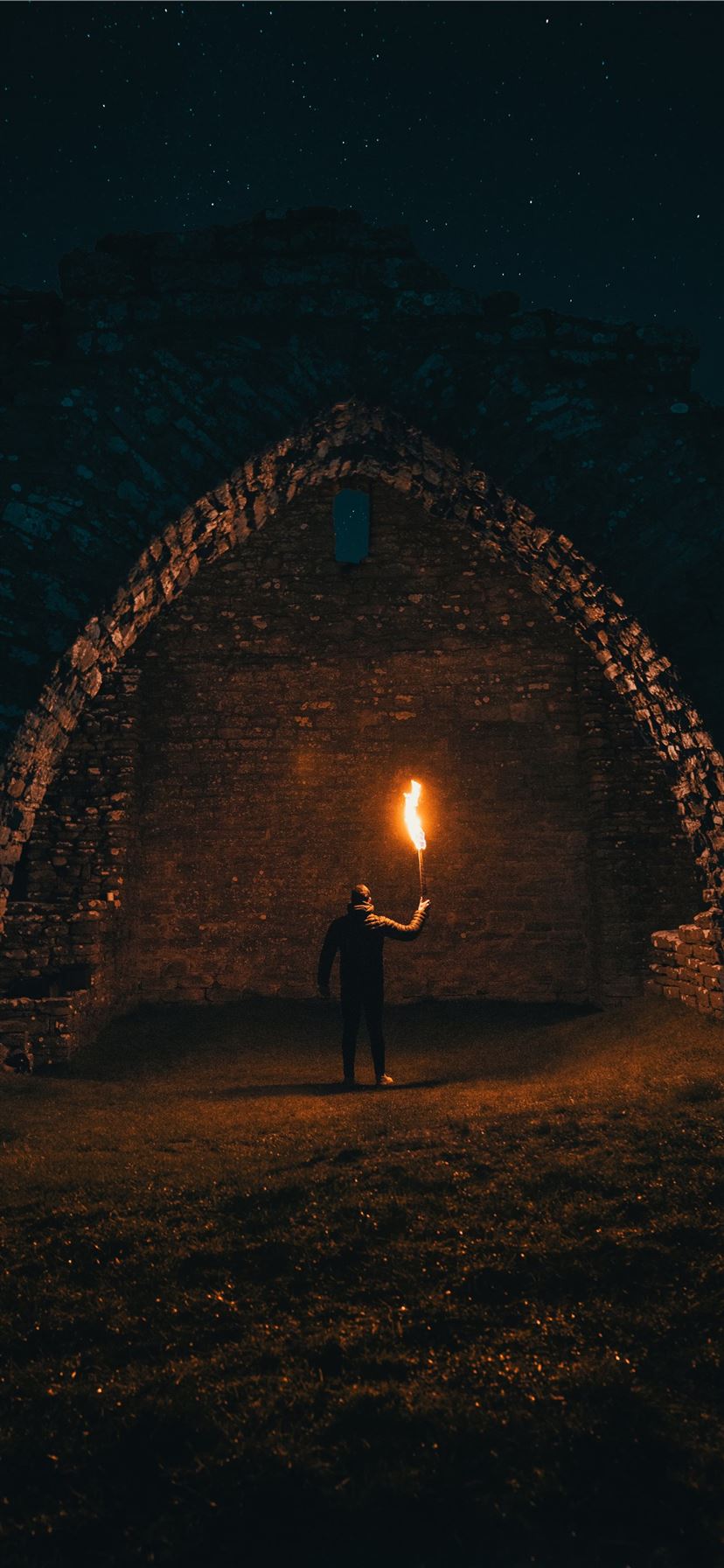 person holding torch in building interior iPhone 11 wallpaper 