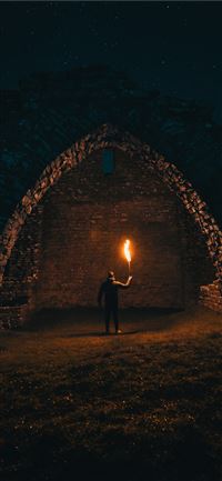 person holding torch in building interior iPhone 11 wallpaper