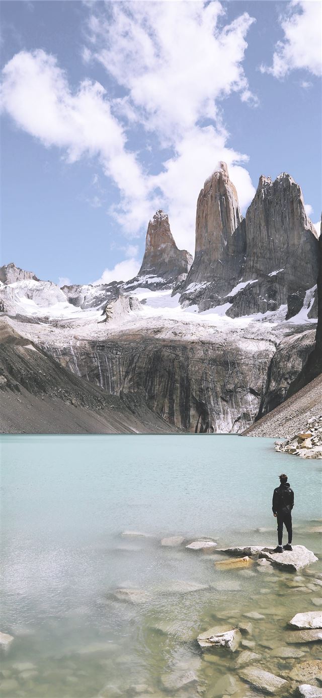 1125x2436 man standing above rock beside body of water under... - mountain iPhone 11 Wallpaper