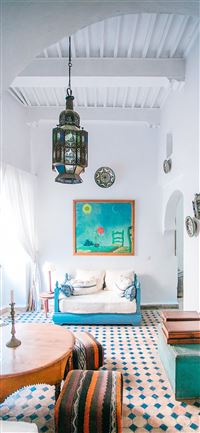 round brown wooden table with two brown ottomans wallpaper