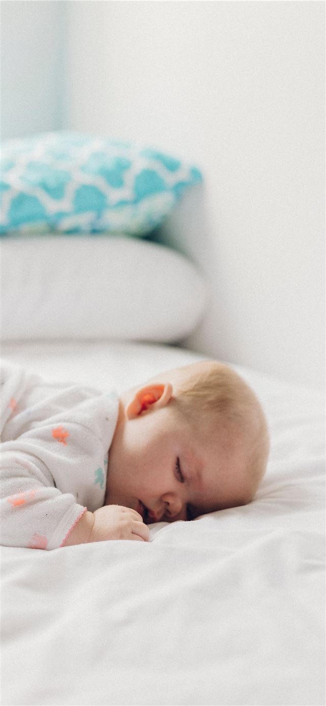 1125x2436 photo of baby laying on bed - cute iPhone 11 Wallpaper