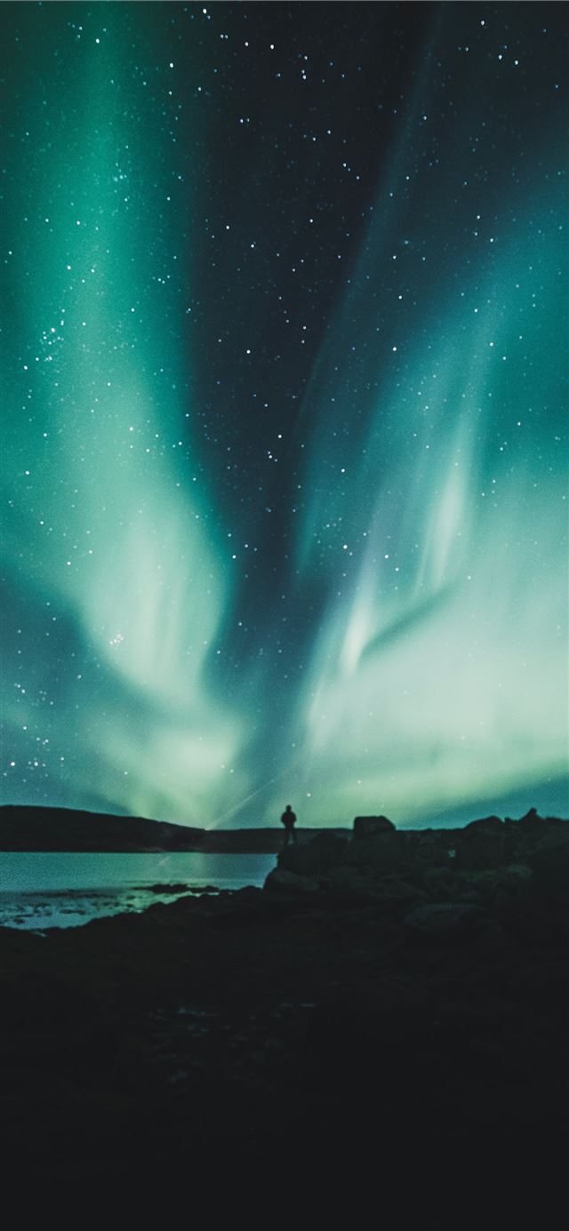 1125x2436 person standing near body of water during aurora n... - westfjords region iPhone 11 Wallpaper