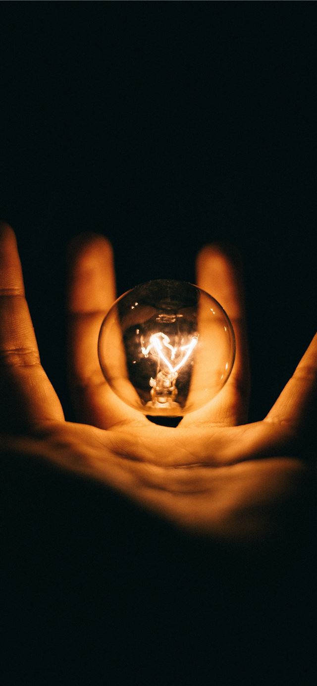 1125x2436 clear glass bulb on human palm - fall iPhone 11 Wallpaper