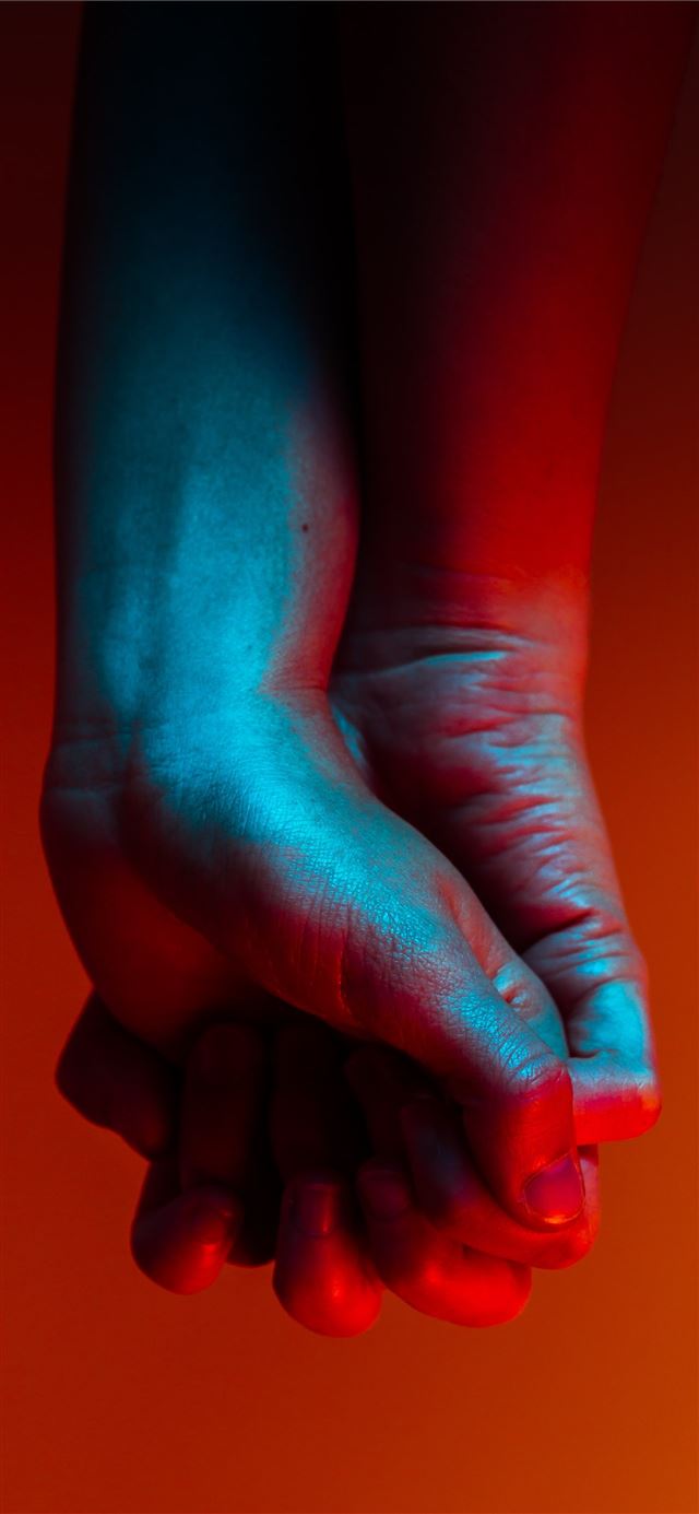 1125x2436 two person holding hands near orange background -  iPhone 11 Wallpaper