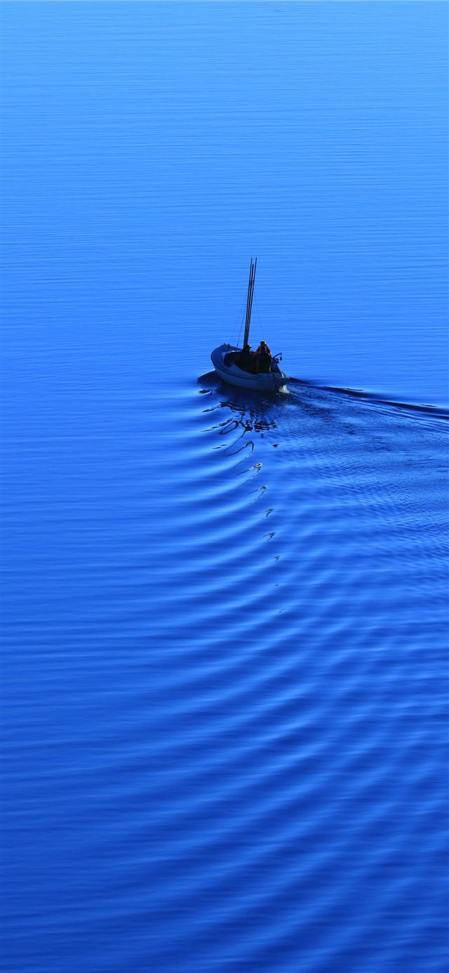 1125x2436 man riding on boat on body of water - ocean iPhone 11 Wallpaper