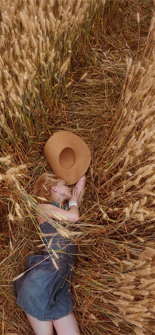 1125x2436 woman lying on wheat field - brown iPhone 11 Wallpaper