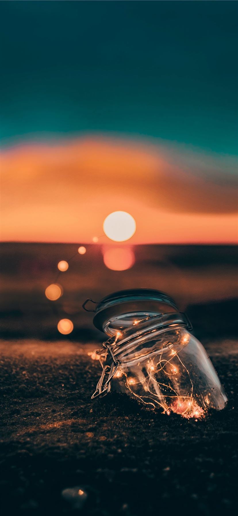 clear glass jar on sand iPhone 11 wallpaper 