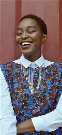 woman smiling beside red wall wallpaper