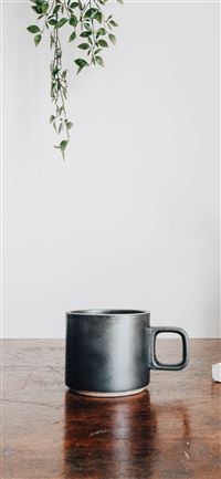 black ceramic mug on brown wooden table iPhone 11 wallpaper