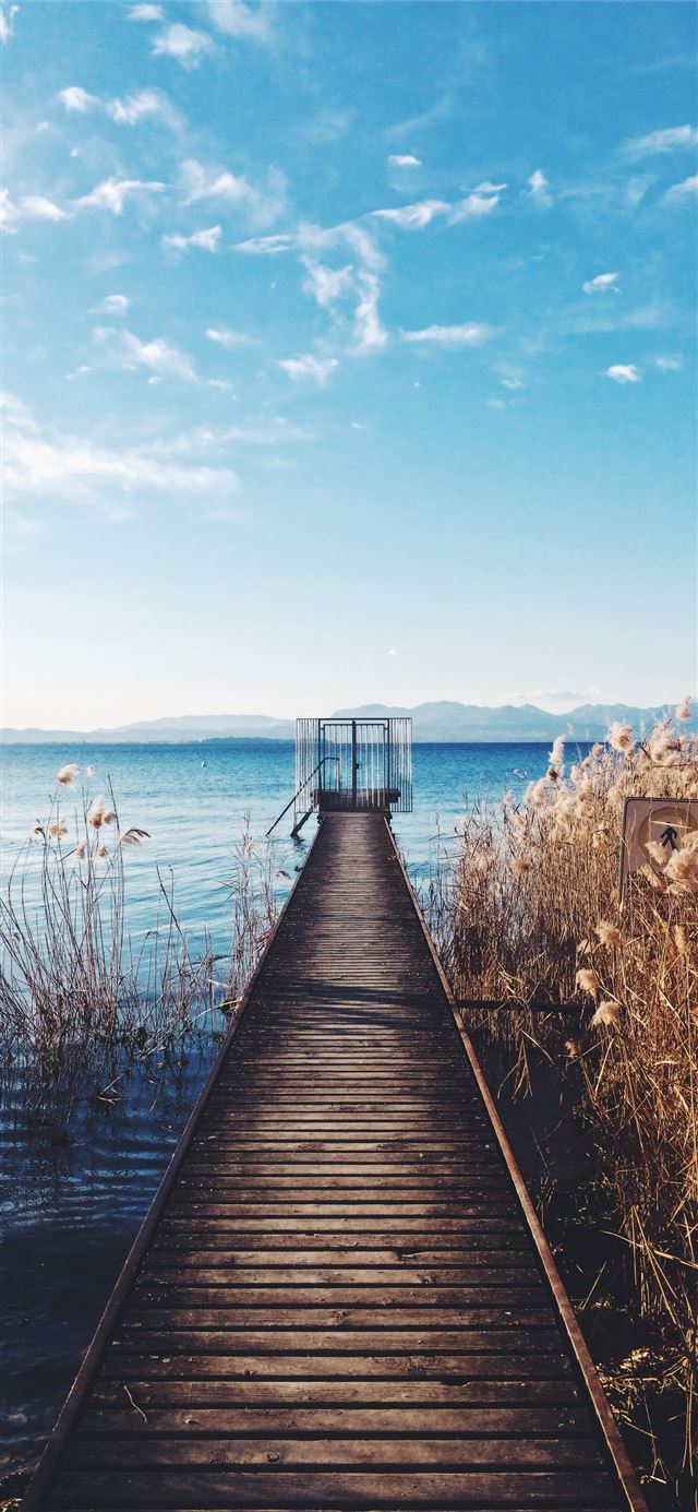 1125x2436 photo of brown wooden boardwalk nearby sea - colorful iPhone 11 Wallpaper