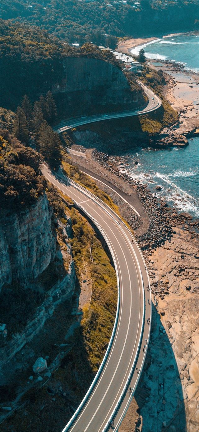 1125x2436 birds eye view of highway beside bay - ocean iPhone 11 Wallpaper