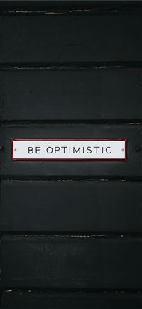 black wooden door with be optimistic text overlay iPhone 11 wallpaper