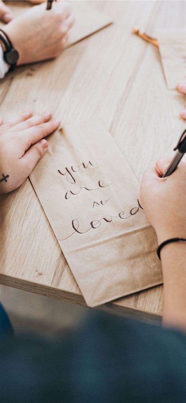 1125x2436 person writing on brown paper -  iPhone 11 Wallpaper