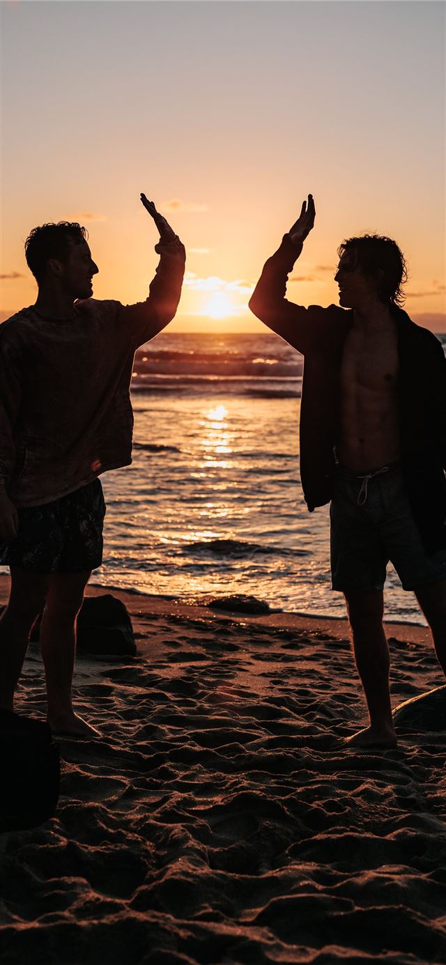 1125x2436 silhouette of two mens near seashore about to high... - beach iPhone 11 Wallpaper