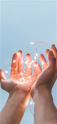 person holding string lights wallpaper