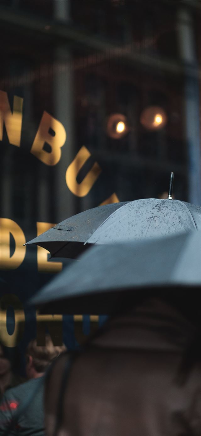 1125x2436 man on blue umbrella - united kingdom iPhone 11 Wallpaper