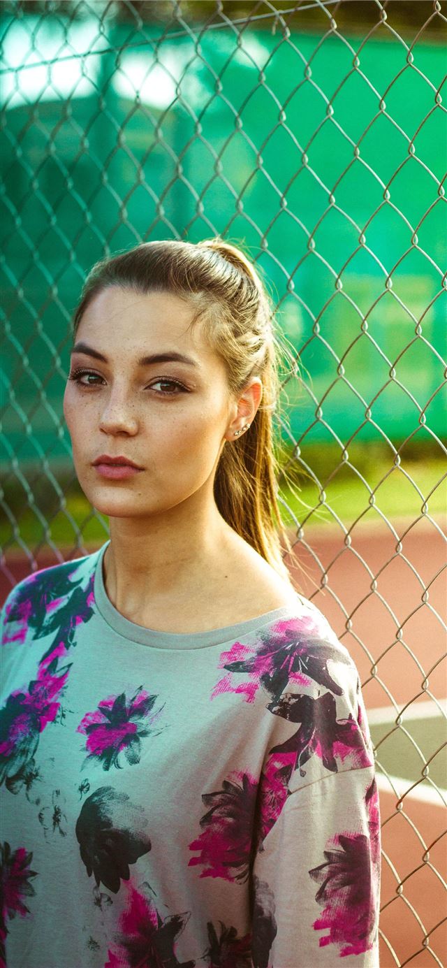 1125x2436 woman wearing floral top beside chain link fence d... - south africa iPhone 11 Wallpaper
