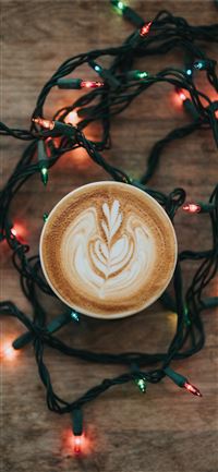 cup of cappuccino and turned on string lights on b... iPhone 11 wallpaper