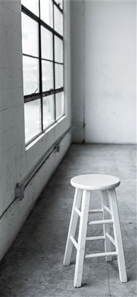 round white wooden stool near closed window wallpaper