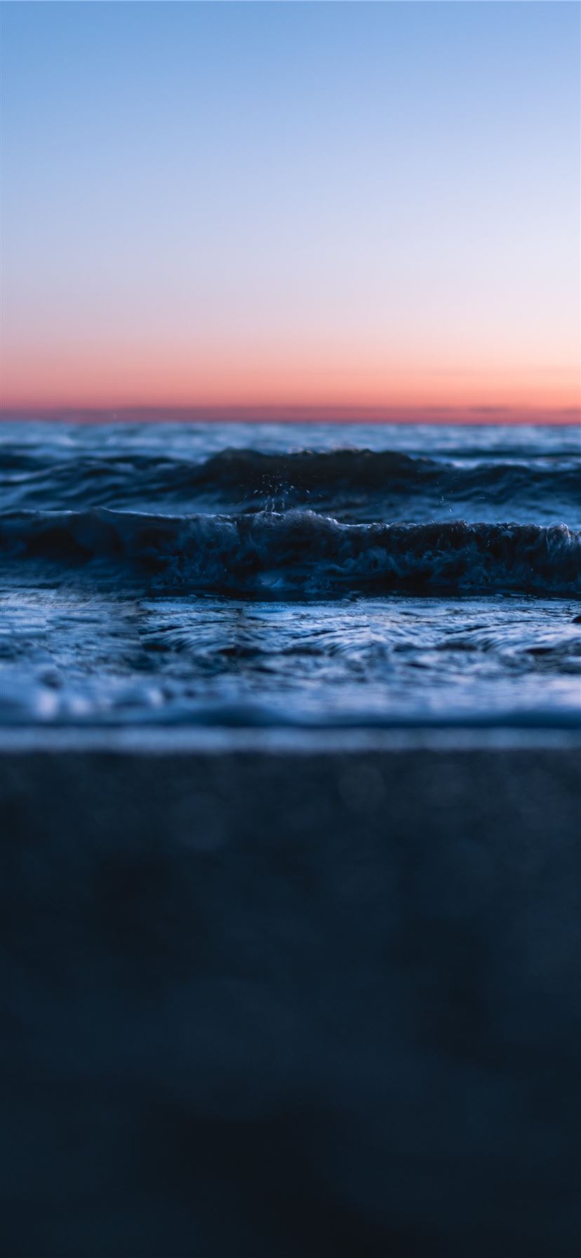 ocean waves crashing on shore during sunset iPhone 11 wallpaper 