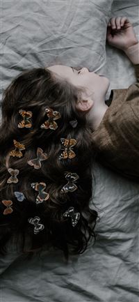 girl lying on gray bed sheet wallpaper