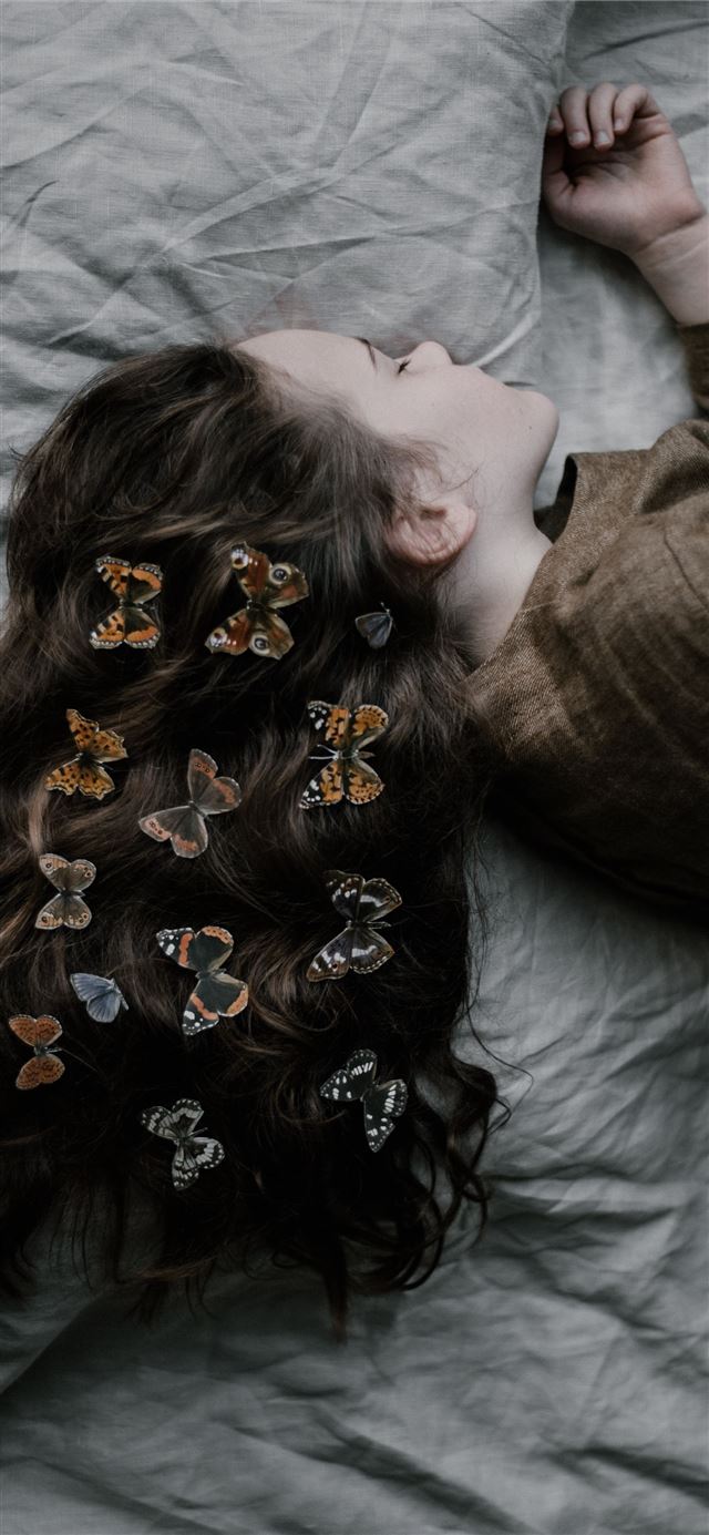 1125x2436 girl lying on gray bed sheet - butterfly iPhone 11 Wallpaper