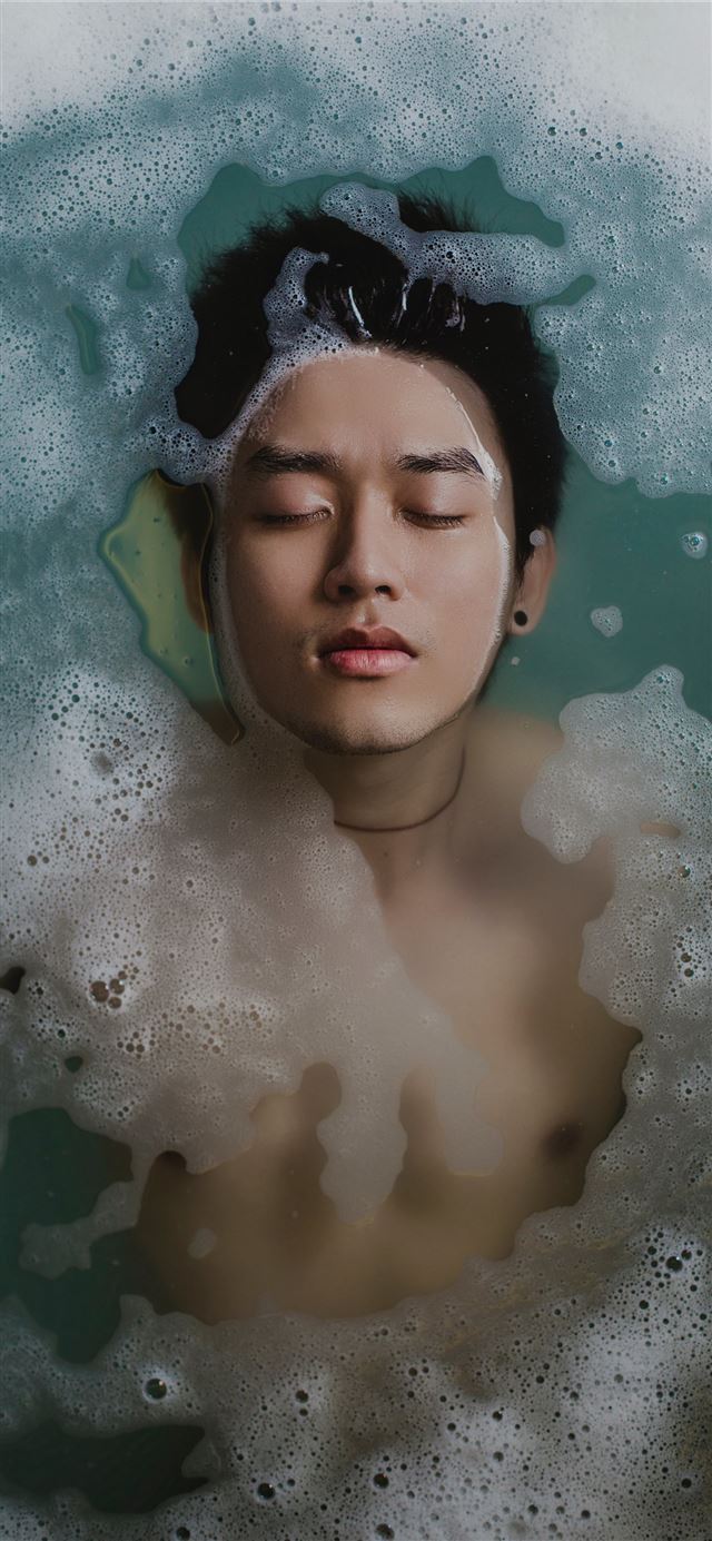1125x2436 man floating in water - vietnam iPhone 11 Wallpaper