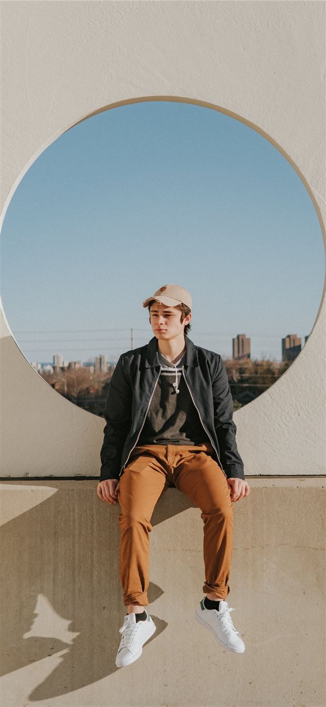 1125x2436 man sitting on gray concrete wall -  iPhone 11 Wallpaper