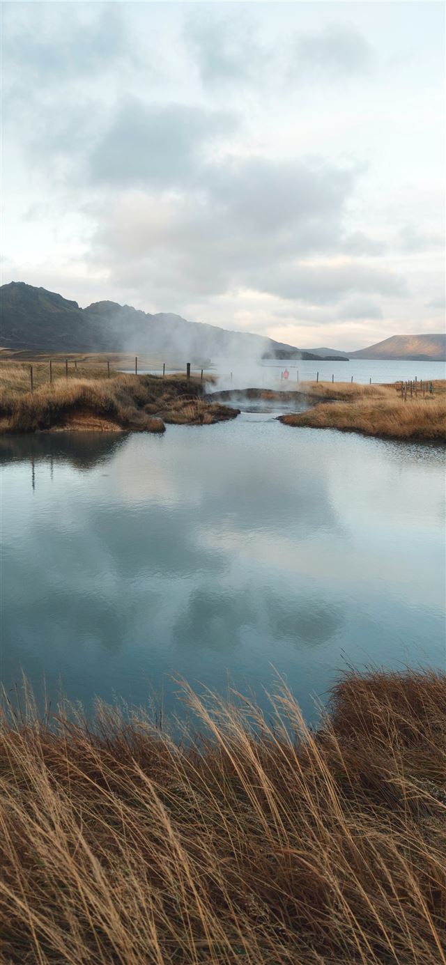 1125x2436 lake near mountain under cloudy sky at daytime - lake iPhone 11 Wallpaper