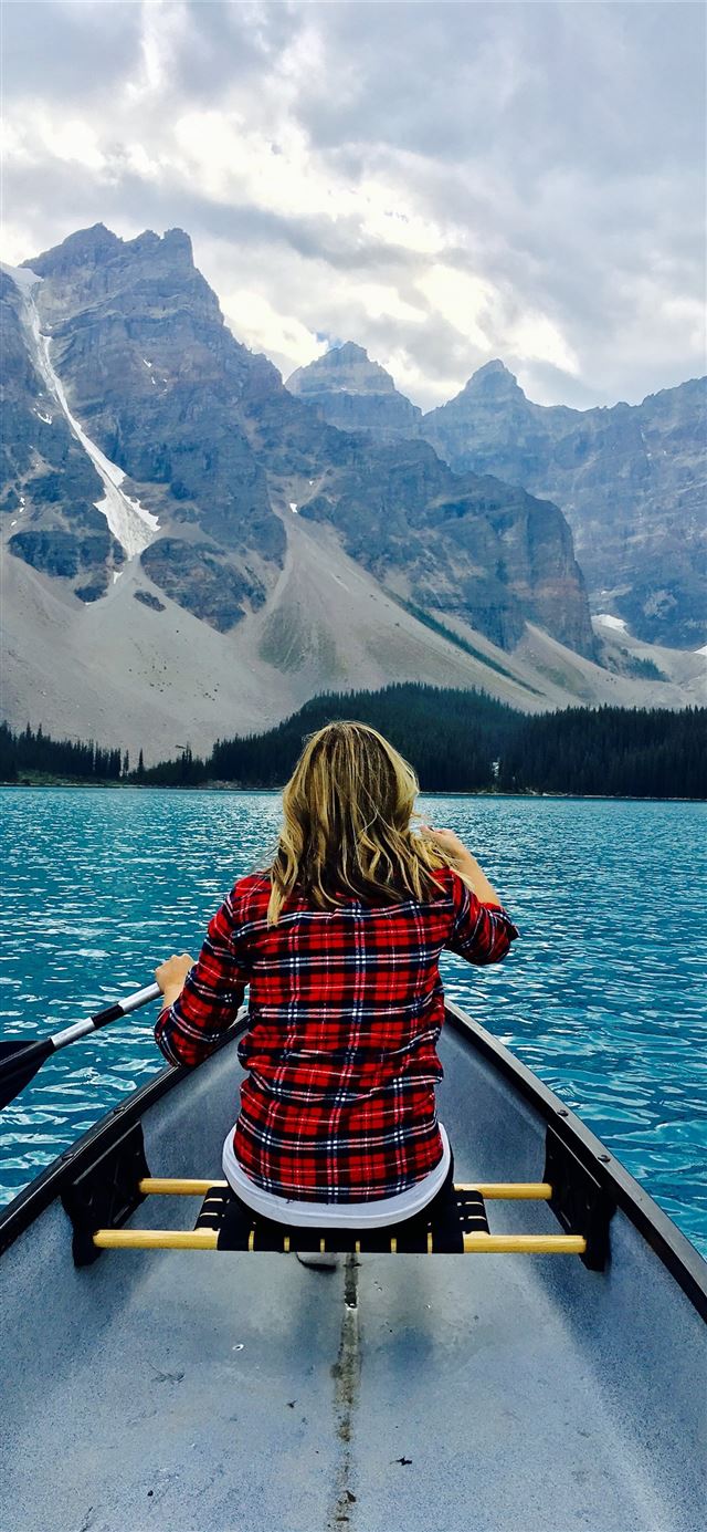 1125x2436 brown haired woman riding boat during day time - moraine lake iPhone 11 Wallpaper
