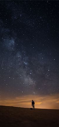 person looking at the milkyway iPhone 11 wallpaper