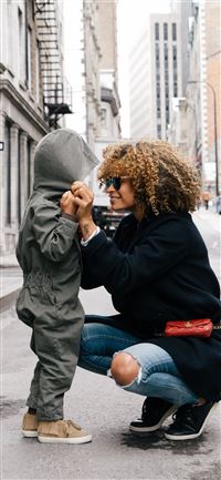 woman holding kid at the street iPhone 11 wallpaper