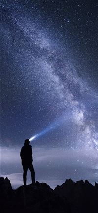 silhouette photo of man using headlamp standing on... wallpaper