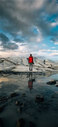 man standing near body of water of water iPhone 11 wallpaper
